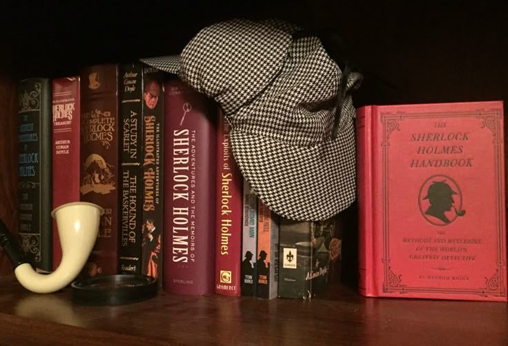 A Sherlock Holmes hat and pipe on a bookshelf